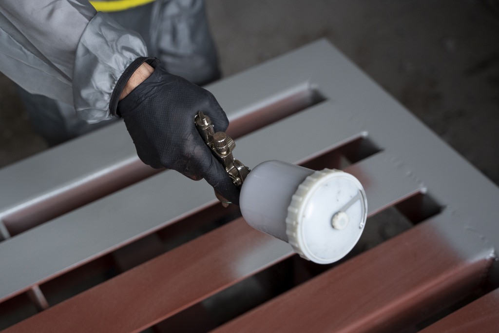high-angle-worker-spraying-powder-paint-from-gun.jpg